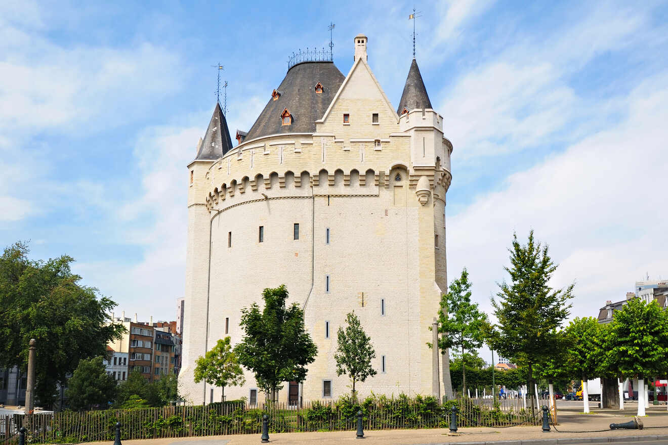 Historic Halle Gate, a medieval fortified city gate in Brussels, against a backdrop of blue sky and greenery